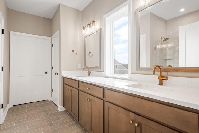 bathroom with a tile shower and vanity