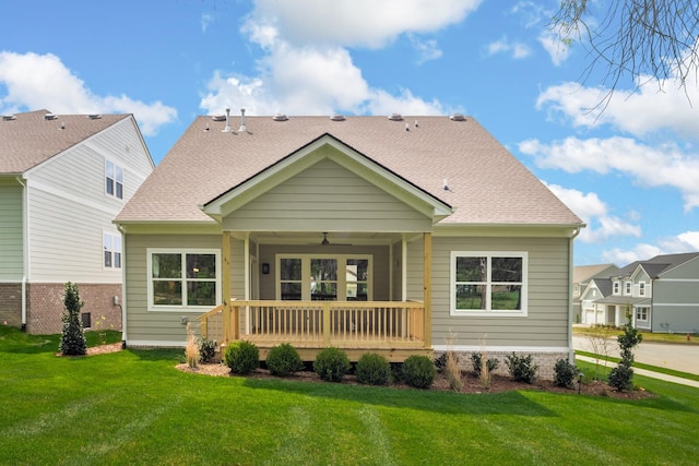 rear view of property featuring ceiling fan, a yard, and covered porch