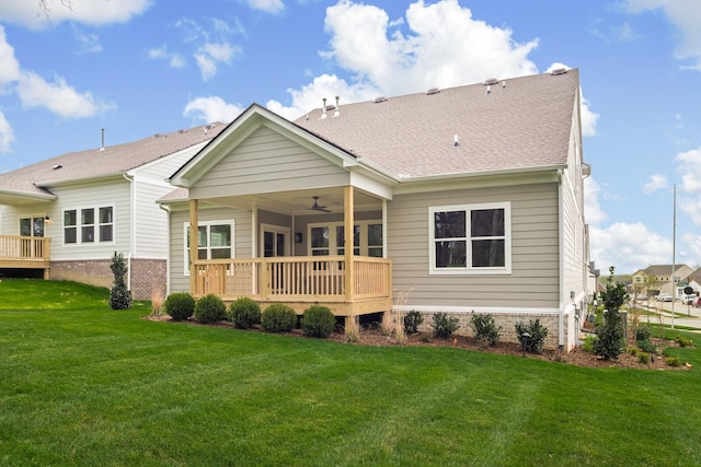 rear view of property with a lawn, ceiling fan, and a deck