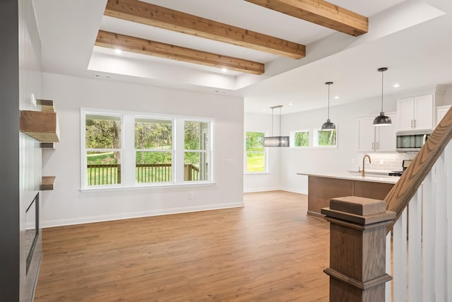 unfurnished living room with beamed ceiling and light hardwood / wood-style flooring