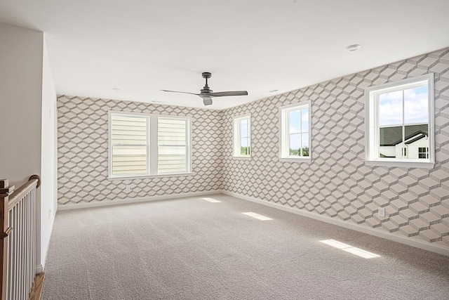 empty room with ceiling fan, a healthy amount of sunlight, and carpet floors