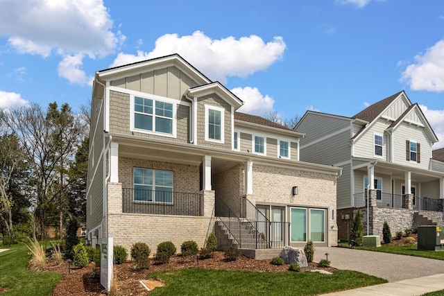 craftsman-style house featuring central air condition unit, a front lawn, and covered porch