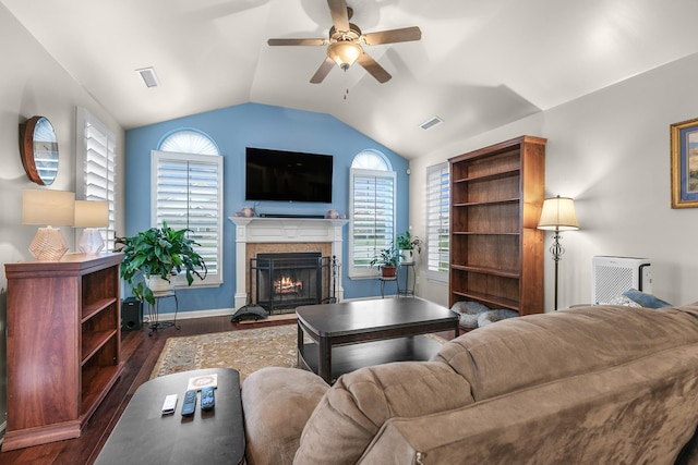 living room with lofted ceiling, a fireplace, dark wood-type flooring, and ceiling fan