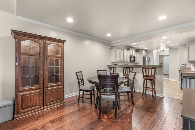 dining room with crown molding and dark hardwood / wood-style floors