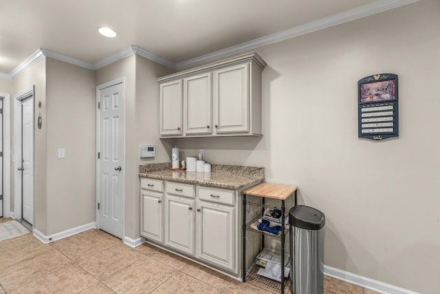 kitchen with light tile patterned floors, ornamental molding, and light stone countertops