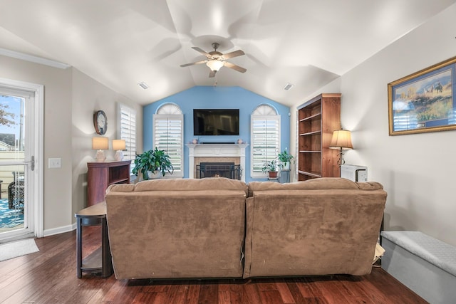 living room with dark wood-type flooring, vaulted ceiling, built in shelves, and ceiling fan