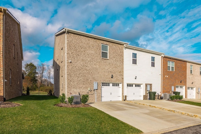 rear view of property featuring central AC, a yard, and a garage