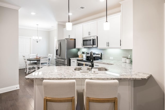 kitchen with white cabinets, decorative light fixtures, dark hardwood / wood-style flooring, kitchen peninsula, and stainless steel appliances