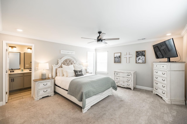 bedroom featuring light carpet, ensuite bathroom, sink, ceiling fan, and ornamental molding