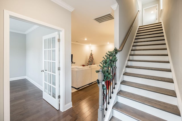 staircase with hardwood / wood-style flooring and ornamental molding