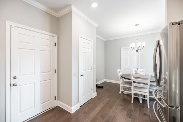 dining area with crown molding, dark wood-type flooring, and a chandelier