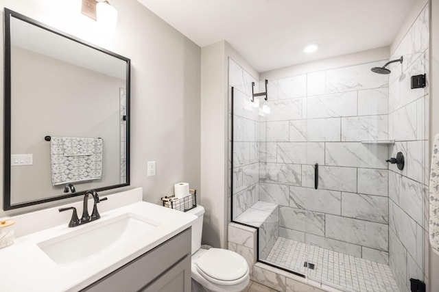 bathroom with an enclosed shower, vanity, and toilet