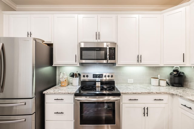 kitchen featuring backsplash, light stone countertops, white cabinets, and stainless steel appliances