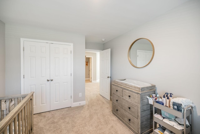 carpeted bedroom featuring a nursery area and a closet