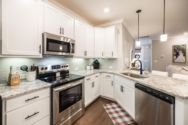 kitchen with pendant lighting, sink, ornamental molding, white cabinetry, and stainless steel appliances