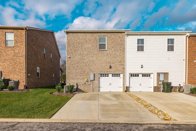 back of house featuring central AC unit, a garage, and a lawn