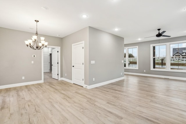 unfurnished room featuring light hardwood / wood-style floors and ceiling fan with notable chandelier