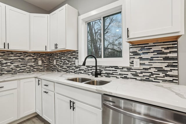 kitchen with decorative backsplash, sink, white cabinets, and stainless steel dishwasher