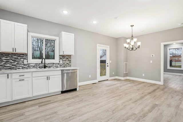 kitchen featuring sink, light hardwood / wood-style flooring, stainless steel dishwasher, decorative backsplash, and white cabinetry