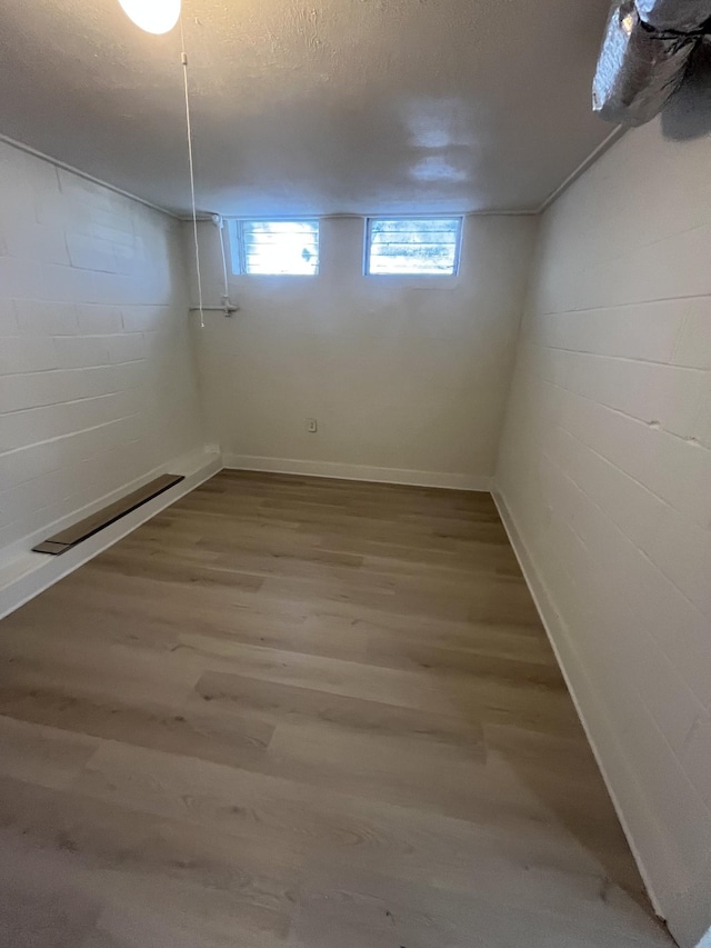 basement with wood-type flooring and a textured ceiling