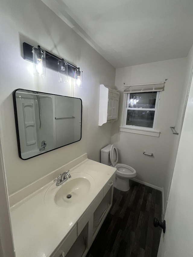 bathroom featuring wood-type flooring, vanity, and toilet