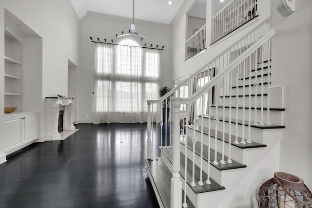 stairs featuring wood-type flooring and a high ceiling