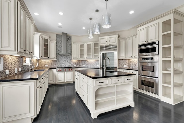 kitchen featuring decorative backsplash, decorative light fixtures, a kitchen island, and wall chimney exhaust hood