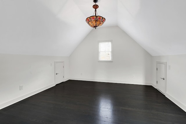 bonus room with vaulted ceiling and dark wood-type flooring