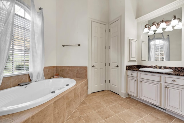 bathroom with tile patterned floors, tiled bath, and vanity