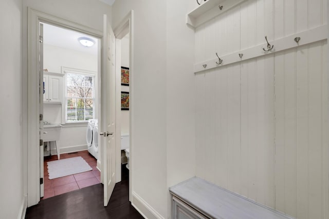 mudroom with dark wood-type flooring and washer / clothes dryer