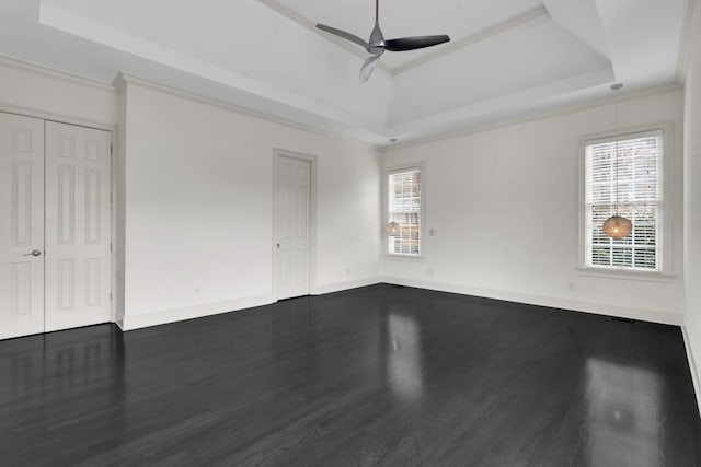 spare room featuring hardwood / wood-style flooring, ceiling fan, ornamental molding, and a tray ceiling