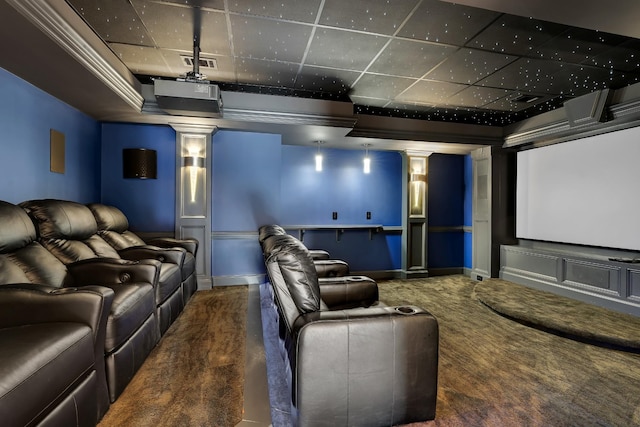 carpeted home theater room with ornate columns and ornamental molding