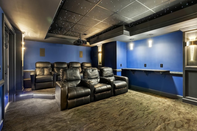 carpeted cinema room with a tray ceiling, a drop ceiling, and ornamental molding