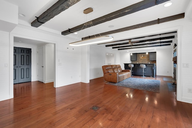 unfurnished living room featuring beam ceiling and dark hardwood / wood-style flooring