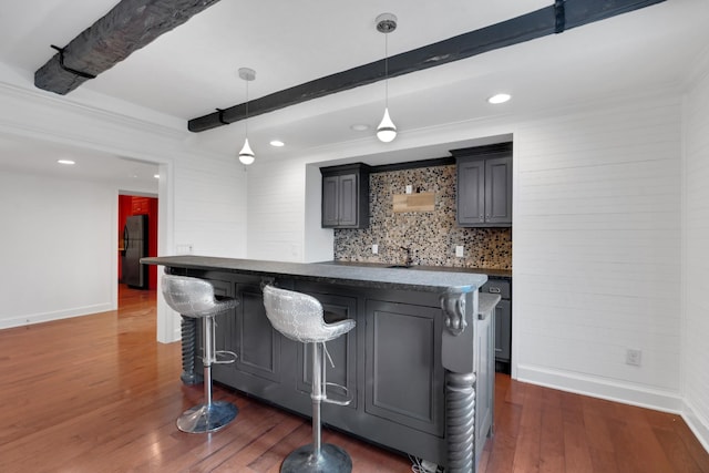 bar featuring beam ceiling, stainless steel fridge, hanging light fixtures, and dark hardwood / wood-style floors