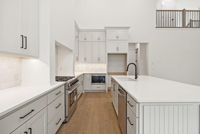 517 Matthew Miller Dr, Smyrna, TN 37167 - kitchen featuring appliances with stainless steel finishes, a high ceiling, tasteful backsplash, light wood finished floors, and light countertops