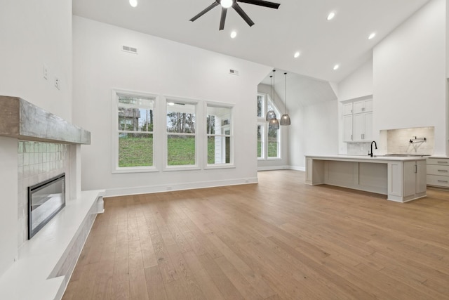 517 Matthew Miller Dr, Smyrna, TN 37167 - unfurnished living room featuring high vaulted ceiling, ceiling fan, a tile fireplace, light wood-type flooring, and recessed lighting