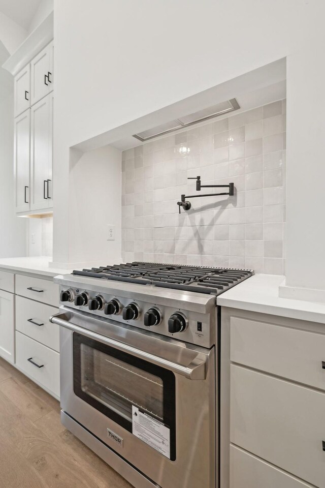 517 Matthew Miller Dr, Smyrna, TN 37167 - kitchen with high end stainless steel range oven, decorative backsplash, light countertops, and light wood-type flooring