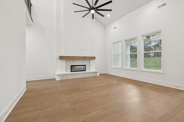 517 Matthew Miller Dr, Smyrna, TN 37167 - unfurnished living room with high vaulted ceiling, wood finished floors, a glass covered fireplace, ceiling fan, and recessed lighting