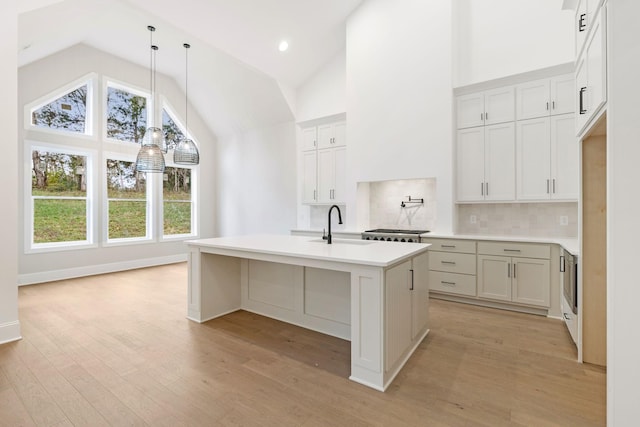 517 Matthew Miller Dr, Smyrna, TN 37167 - kitchen with high vaulted ceiling, healthy amount of natural light, backsplash, light wood finished floors, and an island with sink
