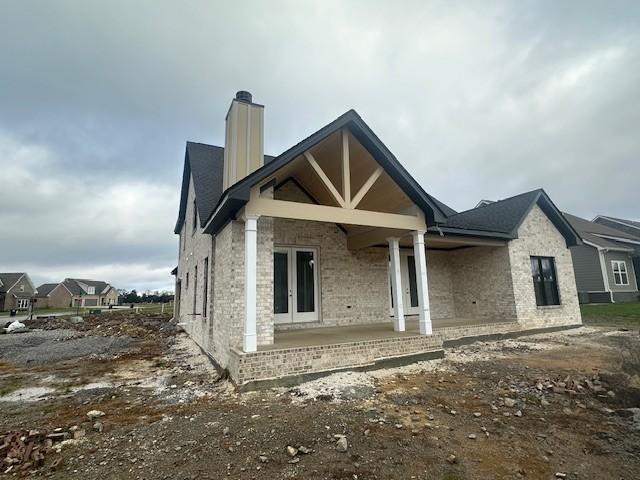 back of property with a porch and french doors