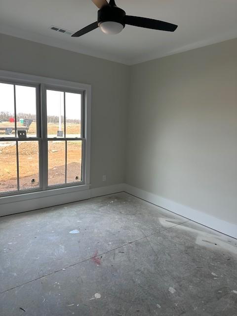 empty room featuring a ceiling fan, visible vents, and baseboards