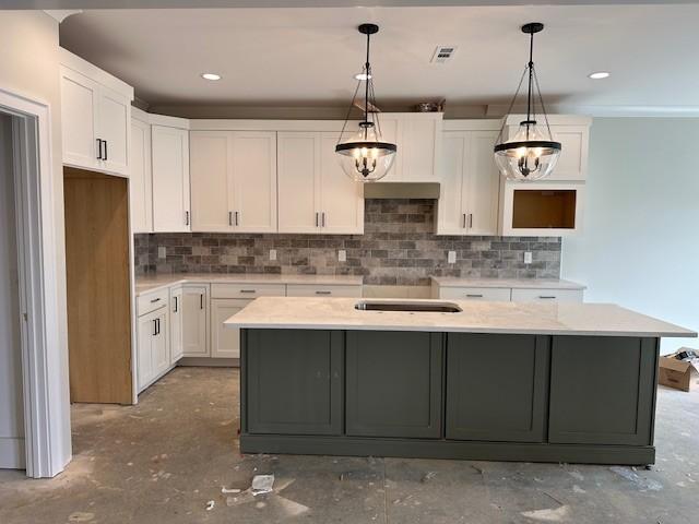 kitchen with hanging light fixtures, a center island, and white cabinets