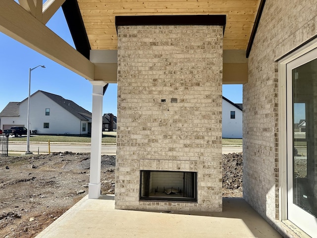 view of patio with an outdoor brick fireplace