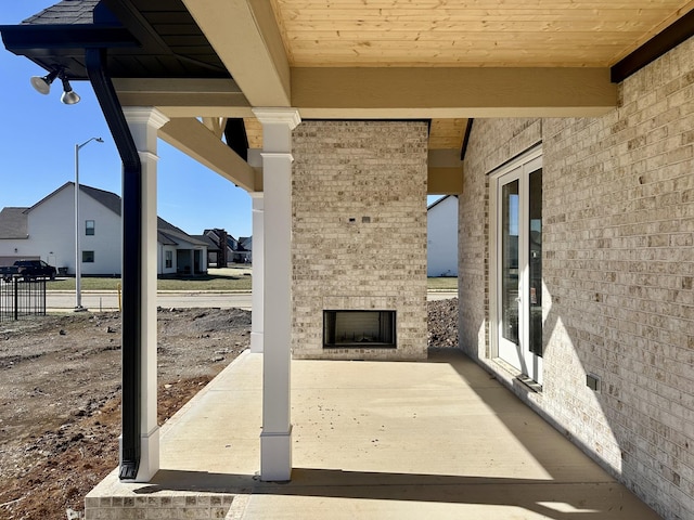 view of patio / terrace with an outdoor brick fireplace and a residential view