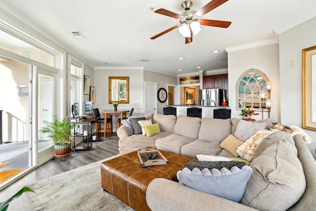 living room with hardwood / wood-style floors, ceiling fan, and crown molding