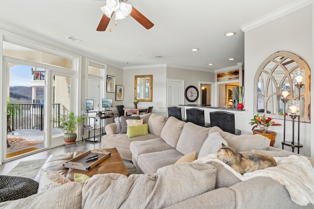 living room with hardwood / wood-style flooring, ceiling fan, and ornamental molding