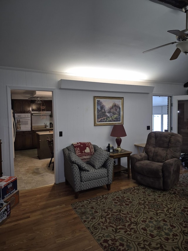 living room featuring hardwood / wood-style flooring, ceiling fan, and vaulted ceiling