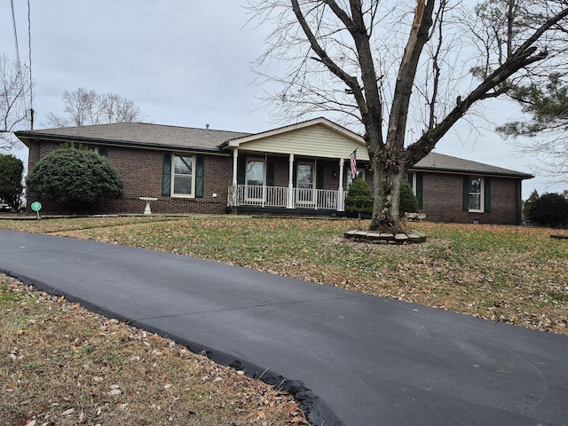 ranch-style home with a porch and a front yard