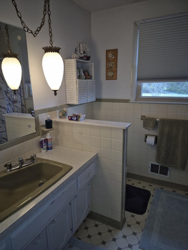 bathroom with tile patterned flooring, vanity, and tile walls